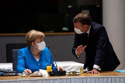 Kanselir Jerman Angela Merkel berbicara dengan Presiden Prancis Emmanuel Macron dalam pertemuan tatap muka pertama pemimpin Uni Eropa di Brussels, Belgia, 17 Juli 2020. Francisco Seco/Pool via REUTERS