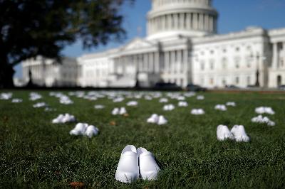 Ratusan sepatu putih dipasang di halaman Gedung Capitol Hill sebagai bagian unjuk rasa perawat Amerika Serikat atas tewasnya ratusan rekan mereka akibat Covid-19, Selasa lalu. REUTERS/Tom Brenner