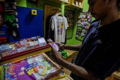 Pedagang tengah mengambil gambar barang dagangannya guna dipasarkan secara daring di Pasar Santa, Jakarta, 21 Juli 2020. Pemerintah terus membenahi insentif untuk UMKM.   Tempo/Tony Hartawan