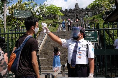 Petugas memeriksa suhu tubuh wisatawan yang akan masuk ke zona 1 kawasan Taman Wisata Candi Borobudur, Magelang, Jawa Tengah, 8 Juli 2020. ANTARA/Anis Efizudin