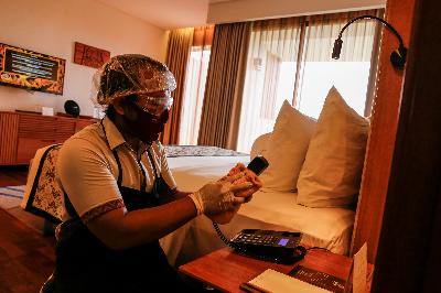 Petugas kebersihan membersihkan gagang telefon dengan cairan disinfektant di Hotel Inaya Putri Bali, Nusa Dua, Bali, 5 Juni 2020. Johannes P. Christo