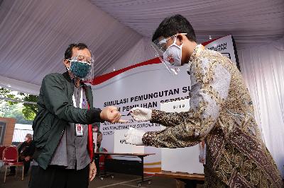 Petugas KPPS memberikan tinta kepada pemilih saat simulasi pemungutan suara Pilkada Serentak 2020 di Kantor KPU, Jakarta, 22 Juli 2020.   TEMPO/M Taufan Rengganis