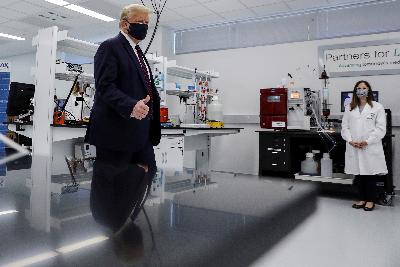 Presiden Amerika Serikat Donald Trump mengenakan masker untuk kedua kalinya di muka publik dalam kunjungan ke Pusat Inovasi Fujifilm Diosynth Biotechnologies di Morrrisville, North Carolina, Senin lalu. REUTERS/Carlos Barria