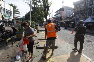 Warga dikenakan hukuman menyapu jalanan tertangkap tidak menggunkan masker saat petugas gabungan Kecamatan Johar Baru melalukan razia masker di kawasan Johar Baru, Jakarta, 24 Juli 2020.  TEMPO/Subekti