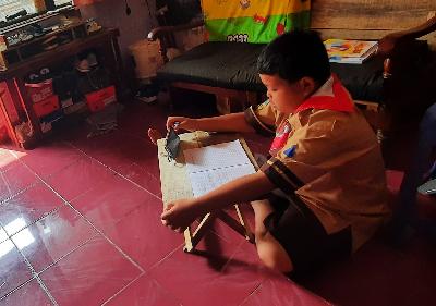 Siswa kelas 3 Sekolah Dasar Angkasa 3, mengikuti pelajaran kelas secara daring dari rumah menggunakan telepon seluler di Kampung Baru, Halim Perdanakusuma, Jakarta Timur, 22 Juli 2020.  TEMPO/Imam Sukamto