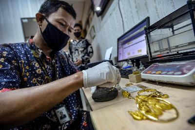 Petugas menakar emas di Kator Pegadaian Syariah, Jakarta, 29 Juli 2020.  Tempo/Tony Hartawan