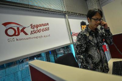 Petugas melayani pengaduan masyarakat melalui telepon di Call Center Otoritas Jasa Keuangan, Jakarta. Tempo/Tony Hartawan