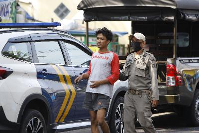 Warga tertangkap tidak menggunkan masker saat petugas gabungan Kecamatan Johar Baru melalukan razia masker di kawasan Johar Baru, Jakarta, 24 Juli 2020.  TEMPO/Subekti