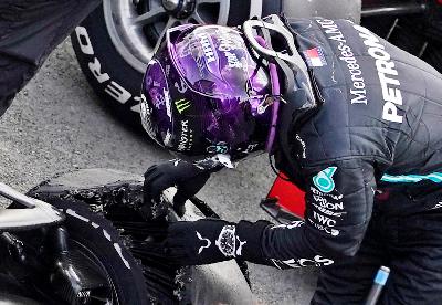 Lewis Hamilton melihat bannya yang pecah setelah berlaga pada British Grand Prix di Silverstone Circuit, Silverstone, Inggris, 2 Agustus 2020.  Pool via REUTERS/Will Oliver
