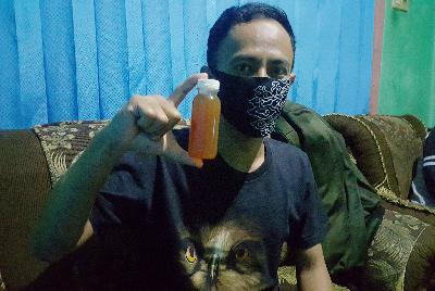 Warga menunjukan botol ramuan herbal antibodi Covid-19 penemuan Hadi Pranoto di kediamannya, Pamijahan, Kabupaten Bogor, 2 Agustus 2020. TEMPO/MA. MURTADHO