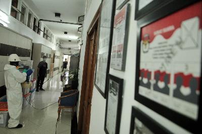 Petugas menyemprotkan cairan disinfektan pada lorong ruangan Komisi Pemilihan Umum Republik Indonesia, di Jakarta, 20 Maret 2020.  TEMPO/Hilman Fathurrahman W