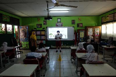Siswa saat bercerita tentang pengalaman hari pertama belajar tatap muka di kelas SDN 06 Pekayon Jaya, Bekasi, Jawa Barat, 3 Agustus 2020.   TEMPO/Hilman Fathurrahman W