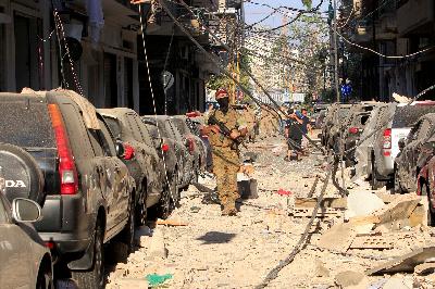 Personel militer berjalan di sepanjang jalan yang hancur di dekat lokasi ledakan di pelabuhan kota Beirut, Rabu lalu. REUTERS / Aziz Taher