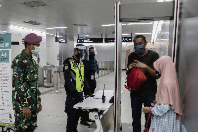 Personel TNI (kiri) mengawasi pelaksanaan protokol kesehatan di Stasiun MRT Bundaran HI, Jakarta, 26 Mei 2020.  TEMPO/M Taufan Rengganis