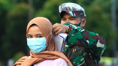 Personel TNI AD memasangkan masker kepada warga yang terjaring razia masker di Taman Digulis, Pontianak, Kalimantan Barat, 12 Juli 2020. ANTARA/Jessica Helena Wuysang