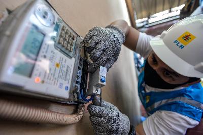 Petugas PLN Unit Induk Distribusi Jakarta UP3 Bulungan sedang melakukan penambahan daya di kWh Meter pelanggan di Cipete Utara, Kebayoran Baru, Jakarta, 6 Agustus 2020. Tempo/Tony Hartawan