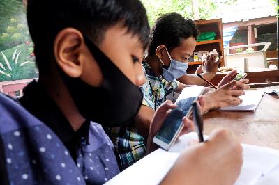 Siswa melakukan pembelajaran jarak jauh dengan memanfaatkan fasilitas WiFi di Bank Sampah Majelis Taklim, Kecamatan Koja, Jakarta, 12 Agustus 2020. TEMPO / Hilman Fathurrahman W