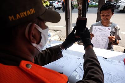 Petugas memotret warga yang melanggar aturan PSBB transisi karena tidak mengenakan masker di kawasan Tendean, Jakarta, 23 Juli 2020. TEMPO / Hilman Fathurrahman W