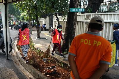 Pelanggar PSBB menjalani hukuman sosial dengan menyapu sampah di kawasan Bundaran HI, Jakarta, 9 Agustus 2020.  TEMPO/Muhammad Hidayat