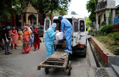 Petugas mengamankan pakaian pelindung saat membawa jasad penderita Covid 19 di New Delhi, India, Sabtu lalu. REUTERS/Adnan Abidi