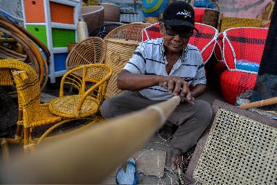 Pekerja menyelesaikan pembuatan mebel dari bahan rotan di kawasan Pramuka, Jakarta,9 Agustus 2018. TEMPO/Tony Hartawan