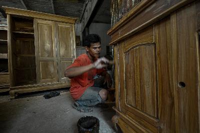 Pekerja menyelesaikan pembuatan lemari di bengkel mebel di kawasan Penggilingan, Jakarta. Tempo/Tony Hartawan
