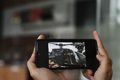 Warga menunjukkan foto kegiatan Ketua KPK, Firli Bahuri, menumpangi helikopter berkode PK-JTO, di Komisi Pemberantasan Korupsi, Jakarta, 25 Juni 2020.   TEMPO/Imam Sukamto