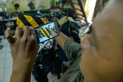 Pekerja memotret produk untuk pasarkan secara daring di lokasi pembuatan tas kamera di kawasan Manggarai, Jakarta, 16 Juli 2020. Tempo/Tony Hartawan