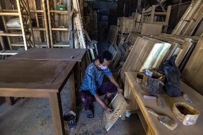 Pekerja menyelesaikan pembuatan meja kayu di bengkel kerja Ridho Jaya Furniture kawasan Klender, Jakarta, 25 Agustus 2020. Tempo/Tony Hartawan
