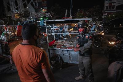 Petugas Satpol PP melakukan sosialisasi pembatasan jam malam ke pedagang kaki lima (PKL) di Jalan Margonda Raya, Depok, Jawa Barat, 31 Agustus 2020. TEMPO/M Taufan Rengganis