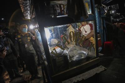 Petugas Satpol PP memberikan sosialisasi pembatasan jam malam ke pedagang kaki lima (PKL) di Jalan Margonda Raya, Depok, Jawa Barat, 31 Agustus 2020.   TEMPO/M Taufan Rengganis