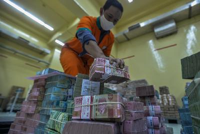 Pekerja memindahkan tumpukan uang rupiah di Cash Center Bank BNI, Jakarta, 10 Juli 2020.  Tempo/Tony Hartawan