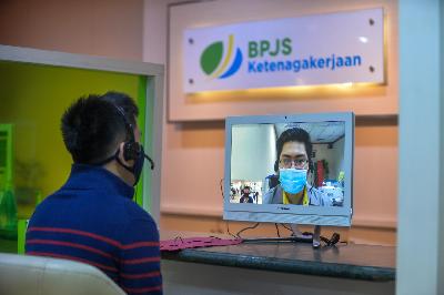 Peserta BP Jamsostek saat melengkapi persyaraytan kepada petugas pelayanan BP Jamsostek secara daring  di kantor Cabang BP Jamsostek Menara Mulia, Jakarta, 23 Juni 2020. Tempo/Tony Hartawan