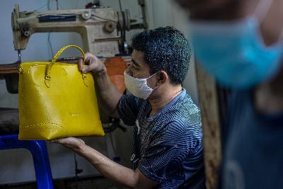 Pekerja menggunakan masker dan menerapkan jaga jarak antar pekerja membuat tas di bengkel kerja pembuatan tas Biyanti di Jakarta, 10 September 2020. Tempo/Tony Hartawan