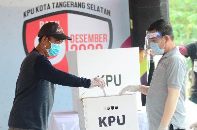 Warga memasukkan kertas suara dalam kegiatan simulasi pemungutan suara dengan protokol kesehatan, di TPS Lapangan PTPN Cilenggang, Serpong, Tangerang Selatan, 12 September 2020.  Tempo/Nurdiansah