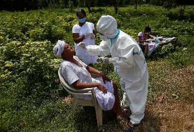 Petugas kesehatan melakukan tes usap terhadap warga di Gujarat, India, 15 September 2020. REUTERS/Amit Dave