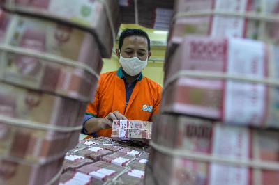 Petugas memeriksa uang rupiah di Cash Center Bank BNI, Jakarta, 10 Juli 2020. Tempo/Tony Hartawan