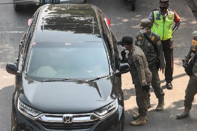 Petugas memberhentikan mobil pada pemeriksaan penggunaan masker saat berkendara dalam Operasi Yustisi Protokol COVID-19 di kawasan Jati Padang, Jakarta, 17 September 2020. TEMPO/Hilman Fathurrahman W