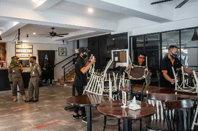 Karyawan restoran mengangkat kursi dan meja saat terjaring razia PSBB Jakarta di kawasan Sunter Agung, Jakarta, 24 September 2020. ANTARA/Aprillio Akbar