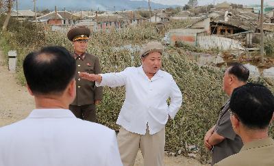 Pemimpin Korea Utara Kim Jong Un meninjau lokasi yang rusak oleh badai di lokasi yang tidak teridentifikasi,  dalam foto yang dipublikasikan pada 5 September 2020.  KCNA via REUTERS