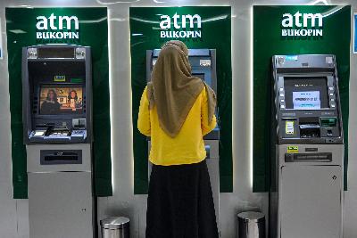 Nasabah melakukan transaksi pada mesin Ajnjungan Tunai Mandiri PT Bank Bukopin Tbk. (BBKP) di Jakarta, 18 Juni 2020. Tempo/Tony Hartawan