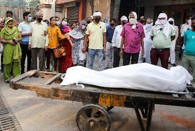 Kerabat berduka di samping tubuh korban Covid-19 di New Delhi, India, 28 September 2020. REUTERS/Adnan Abidi