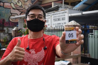 Sukarelawan uji klinis vaksin SARS-CoV-2 menunjukan nomor antrian periksa di Puskesmas Dago, Bandung, Jawa Barat, 11 Agustus 2020.  TEMPO/Prima Mulia