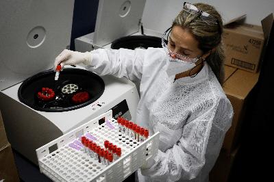 Peneliti mengambil sampel darah dari centrifuge saat studi vaksinasi coronavirus (COVID-19) di Pusat Penelitian Amerika, Florida, 24 September 2020. REUTERS/Marco Bello