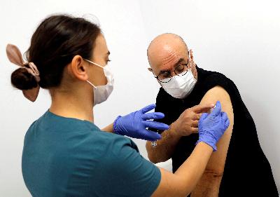 Petugas kesehatan menyuntikkan vaksin dari Cina kepada sukarelawan saat uji coba Fase III di Rumah Sakit Riset Universitas Kocaeli, Turki, 25 September 2020. REUTERS/Murad Sezer
