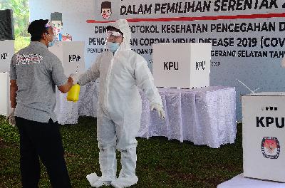 Petugas mengenakan Alat Pelindung Diri (APD) diseterilisasi saat simulasi pemungutan suara di TPS Lapangan PTPN Cilenggang, Serpong, Tangerang Selatan, 12 September 2020.  Tempo/Nurdiansah