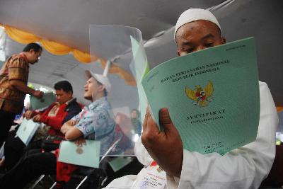 Warga menerima sertifikat tanah yang baru diterima dari Presiden Joko Widodo di Soreang, Kabupaten Bandung, Jawa Barat, 2017.  Tempo/Prima Mulia