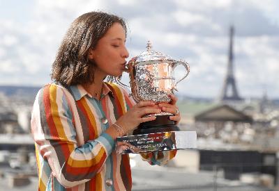 Iga Swiatek mencium piala Perancis Terbuka di  Galeries Lafayette Rooftop, Paris, Perancis, 11 Oktober 2020. REUTERS/Charles Platiau