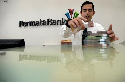 Petugas teller menghitung uang rupiah di kantor pusat Bank Permata, Jakarta. TEMPO/Tony Hartawan
