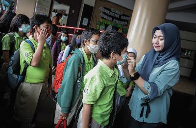 Guru memeriksa masker yang digunakan siswa di Sekolah Dasar Tunas Global, Depok, Jawa Barat, 3 Maret 2020. TEMPO/M Taufan Rengganis
